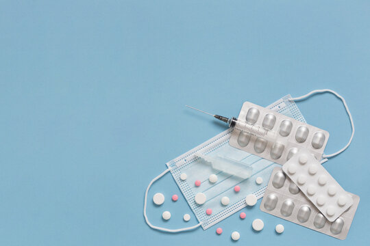 Protective face mask, pills, ampulla with vaccine, expendable syringe for vaccination. Treatment concept various infection and virus diseases.