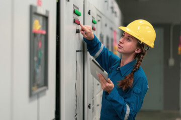 Portrait shot half body of young female electrical engineer in electrical control room, action...