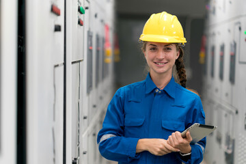 Portrait shot half body of young female electrical engineer in electrical control room, action thump up showing the good services working and professional concept.