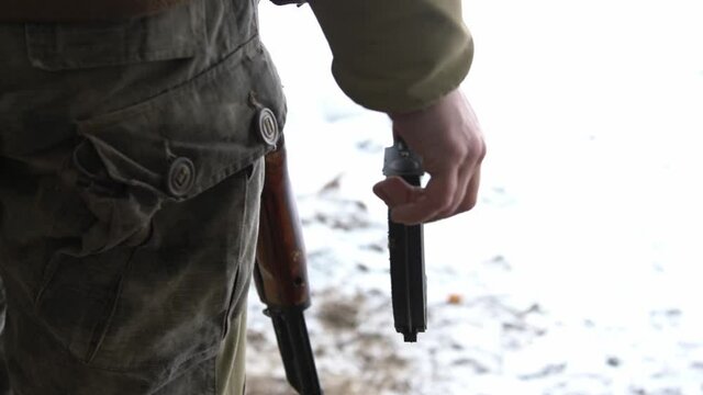 an armed man holding a cartridge for an AK47 rifle in his right hand, close-up, full hd, no sound.