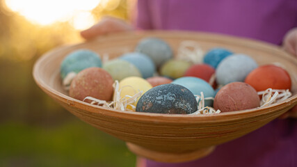 Girl holding a wooden plate with easter eggs