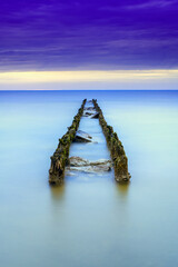 Old wooden breakwater at the beachat sundown,long time exposure photo