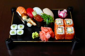 set from beaters and sushi on a support against a dark background