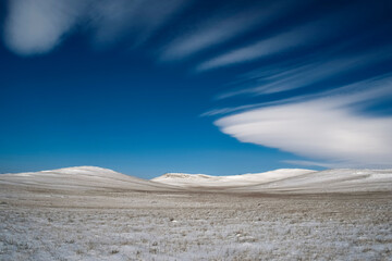 Winter snowy landscape with lenticular clouds, blue sky. Desktop wallpaper Irkutsk region, Russia