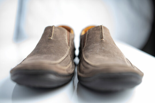 Men's leather loafers of brown color close-up on a light background.