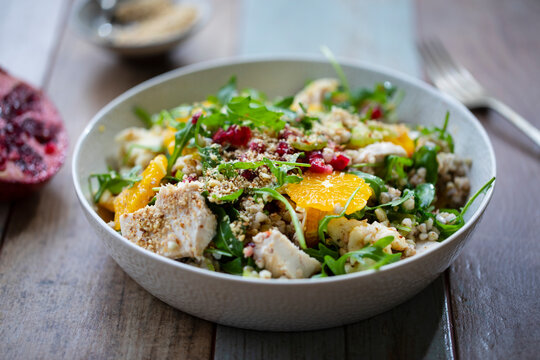Salad with buckwheat, orange and pomegranate seeds, chicken and halloumi