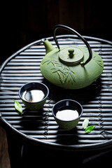 Green tea with teapot on bamboo table. Chinese cuisine.