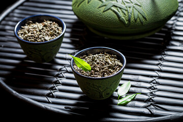 Green leaves in teacup and teapot. Chinese cuisine.