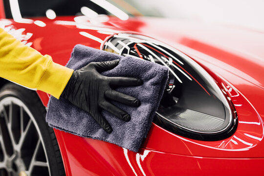 A man cleaning car with cloth, car detailing (or valeting) concept. Selective focus.