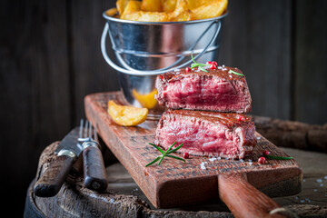 Medium-rare steak and chips with salt and rosemary. American cuisine.