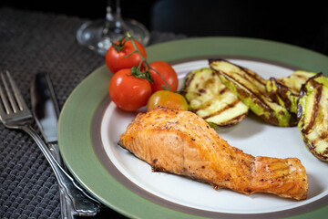 Grilled salmon with zucchini and cherry tomatoes.