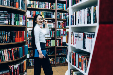 Young female looking for books in library