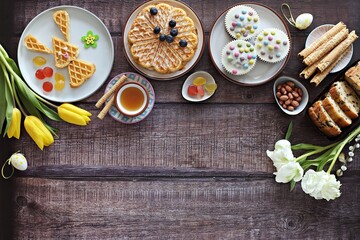 Flat layot from  festive dessert table with various of waffles, cake, muffins and sweets.