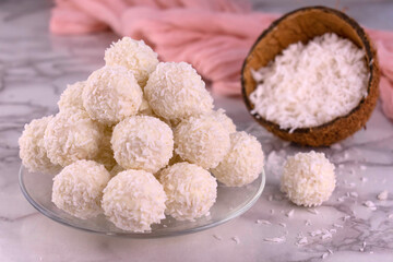 Coconut candies in the shape of a ball on a plate.
Close-up.