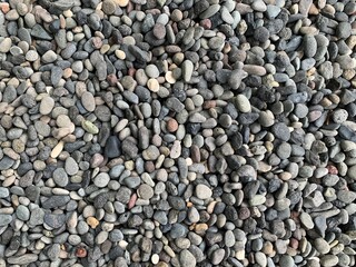 Beach stones as decoration for the front yard of the house. Gravel texture.