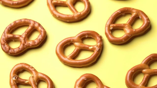 mini salted pretzels on yellow background. hard crackers or snacks. top view, above, dolly                                                 