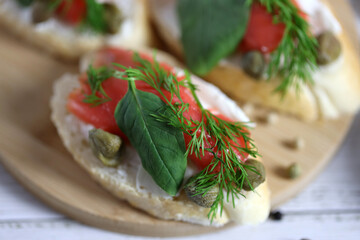 small sandwich with red fish, cream cheese, fresh spinach and capers 