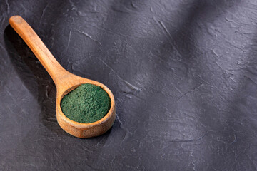 Spirulina powder in wooden spoon - Healthy food