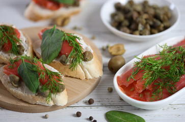 small sandwich with red fish, cream cheese, fresh spinach and capers 