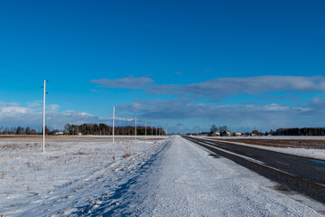 Road and frosted electric poles. Perspective.