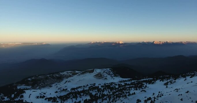 French Alpine peaks at Chamrousse France during sunrise  Aerial pan left orbit panorama