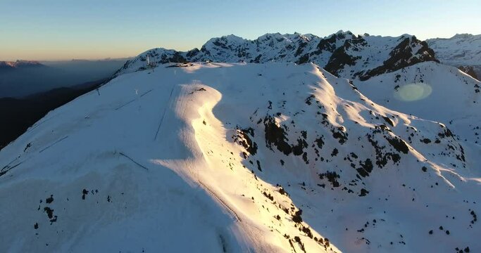 Ski downhill track at Chamrousse on the French Alps during sunrise, Aerial dolly out shot