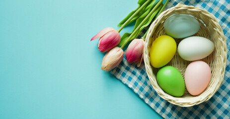 close up top view group of Easter eggs and tulip flowers on blue pastel color background with copy space for design in festival concept
