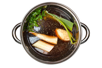 Mushroom soup decoction with celery, leek and parsley in a steel pot, isolated on a white background, top view.