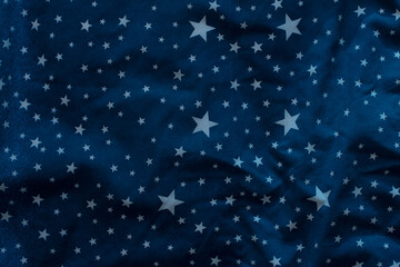 Dark blue textile background with white stars.