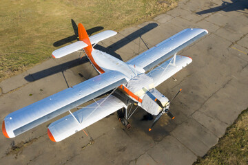 A small plane stands in the parking lot of an old airfield. Wings. Airport. Airfield. Flights by plane.