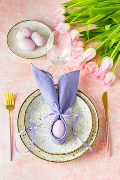 Easter table setting with pink tulip flowers and easter egg