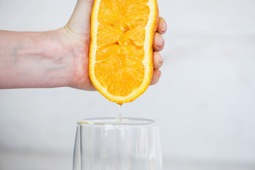 Hand squeeze orange and juice drop down