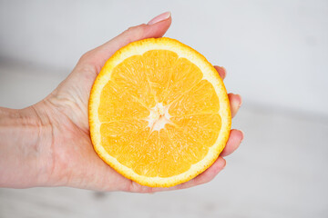 Female hand hold orange to squeeze juice