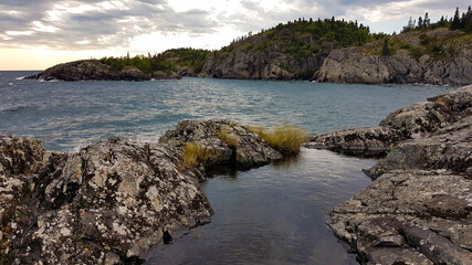 Scenic untouched landscape of a Lake Superior bay in the Pukaskwa Nationalpark. Photographed from a low angle showing a high positioned shallow pond reflecting the sunlight