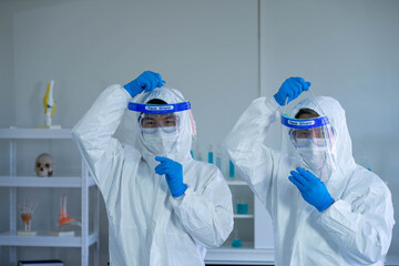 Asian Medical Scientists wearing PPE protective suit working in laboratory  
