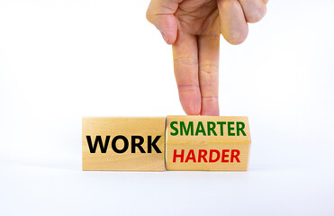 Work harder or smarter symbol. Businessman turns wooden block and changes words 'work harder' to 'work smarter'. Beautiful white background, copy space. Business and work harder or smarter concept.