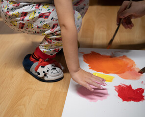 little boy draws with hand on canvas