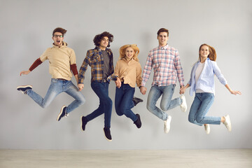 Full-length studio portrait of enthusiastic caucasian european teenager jumping high rejoicing start of holidays, end of academic year or quarantine, getting education grant or admission to university