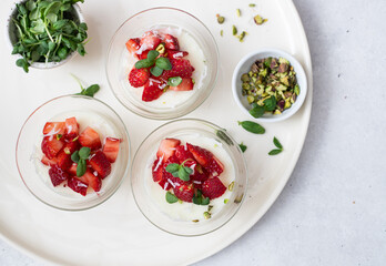 Healthy dessert of natural yogurt with strawberries and pistachios