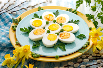Halves of boiled eggs on a blue plate, close up view. Easter, a healthy snack