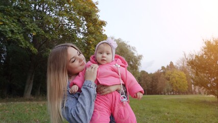 Young mother with her daughter on a warm autumn evening.