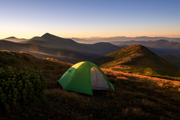 Green camping tent on top of mountain