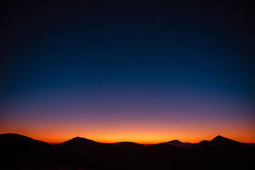 Obraz premium Silhouette of mountain peaks during summer sunset