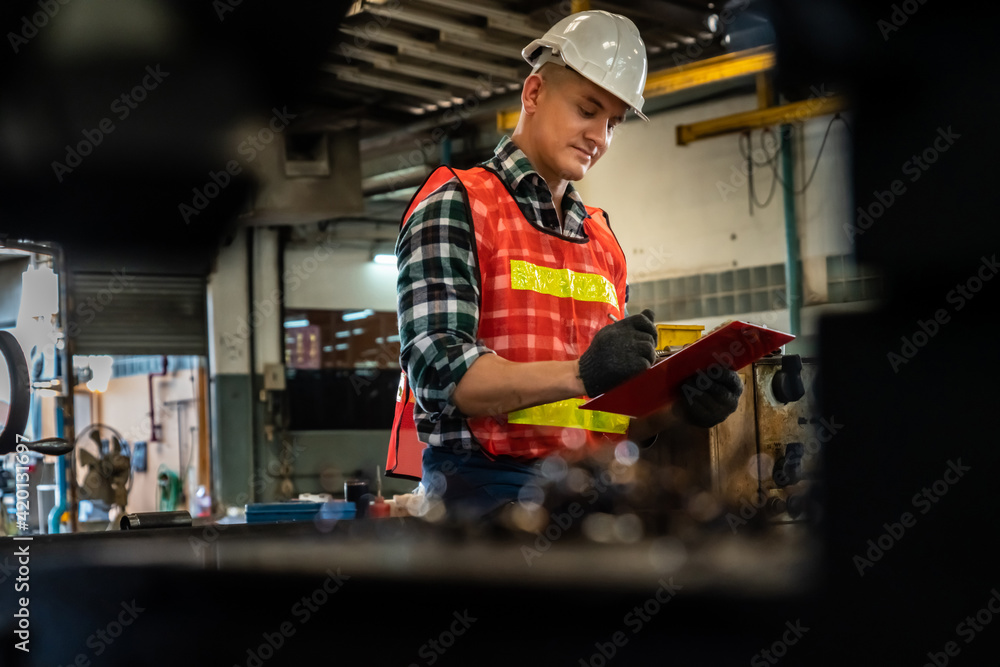 Poster manufacturing worker working with clipboard to do job procedure checklist . factory production line 