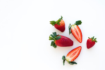 Large ripe strawberries, whole and cut in half close-up isolated on a white background, place for text.