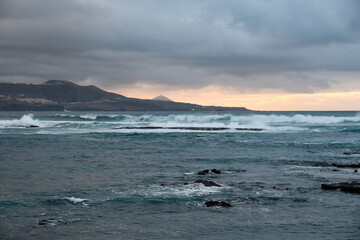 Big powerful waves at the beach hit breakwater. Winter season, windy and stormy weather.	