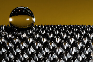 Pearl in metal knurled in dark yellow background