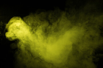 Colorful smoke close-up on a black background. Yellow cloud of smoke.