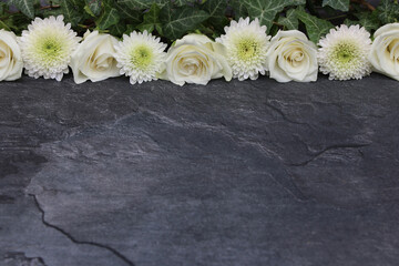 Obraz na płótnie Canvas Weiße Rosen mit Chrysanthemen auf dunklem Hintergrund