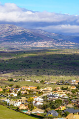 Fototapeta na wymiar Aerial view green mountain landscape with dark clouds and villages with houses on the mountainside. Navacerrada Madrid.